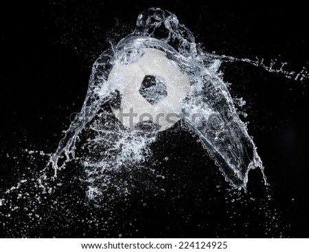 Water splash with sport ball on black background