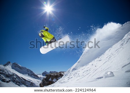 Snowboarder in high mountains during sunny day.