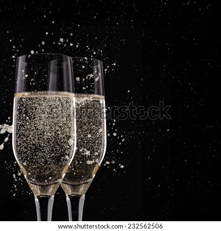 Champagne flutes on black background, celebration theme.