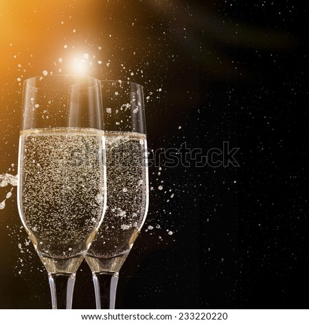 Champagne flutes on black background, celebration theme.
