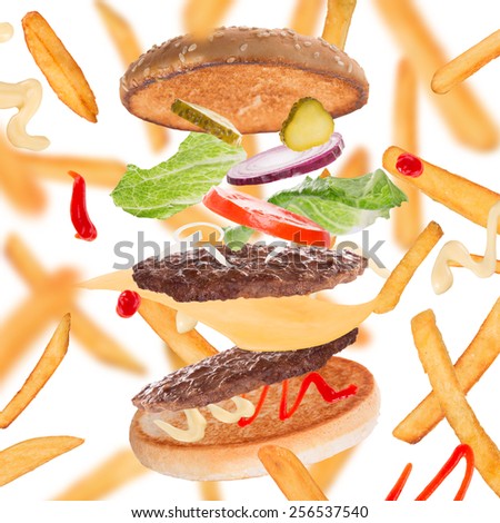 French fries with burger in freeze motion isolated on white