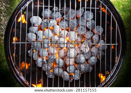 Garden grill with blistering briquettes, close-up.