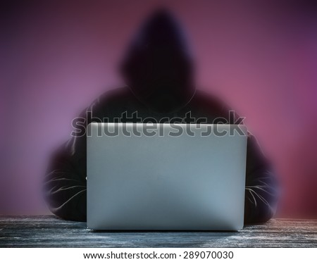 Computer hacker silhouette of hooded man with notebook