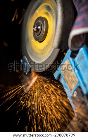 Grinding machine in action with bright sparks. Construction and manufacturing theme.