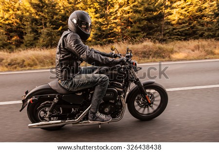 ROUSINOV - SEPTEMBER 29: Harley-Davidson Motorcycle Sportster Iron 883, drives through the forests during sunrise. September 29, 2015 in Rousinov, Czech republic.