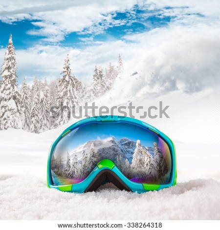Colorful ski glasses on snow. Winter ski theme.