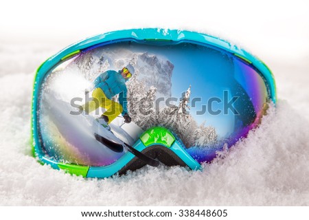 Colorful ski glasses with skier on snow. Winter ski theme.