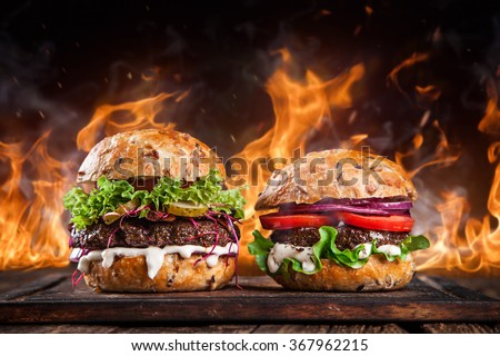Close-up of home made burgers with fire flames.