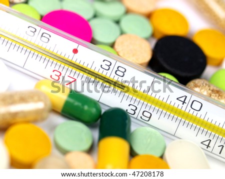 close-up medical pills and tablets with clinical thermometer