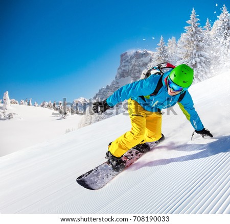 Active man snowboarder riding on slope, snowboarding closeup.