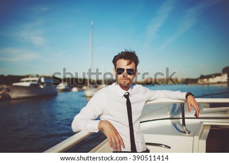 Business portrait of young man in suit posing on a yacht