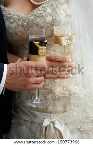 wedding glasses in hands of the bride and groom, wedding rings
