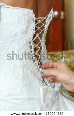 mother  tighten the corset wedding dress  daughter