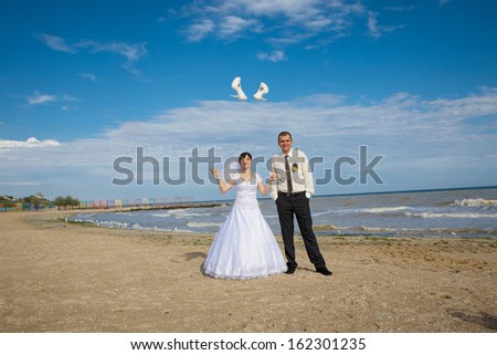 Cheerful couple  groom and bride throw shoes