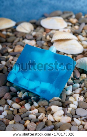 Natural skincare products of  exfoliating scrub, soap and sea shells on background  sea pebble