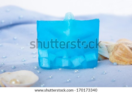 Natural skincare products of  exfoliating scrub, soap and sea shells on a blue background