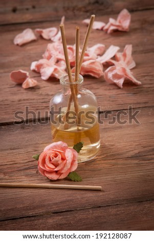 Fragrance sticks or Scent diffuser with rose flowers on wooden background