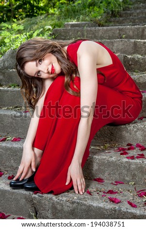 sexy woman in red dress sitting on stairs