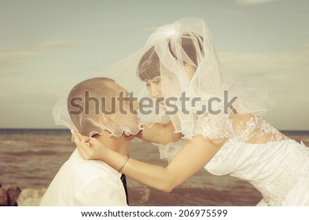 bride and groom  gentle kiss  against the background of the sea