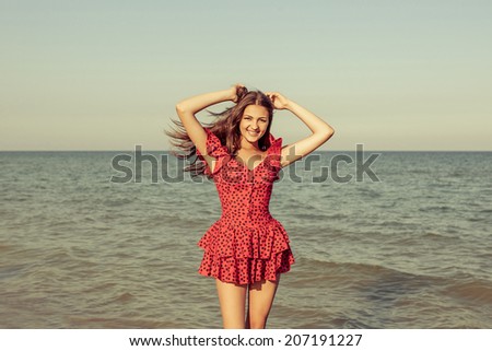 Young happiness woman in red dress on the Bathing Beach