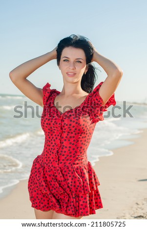 Young happiness girl in red dress on the Bathing Beach