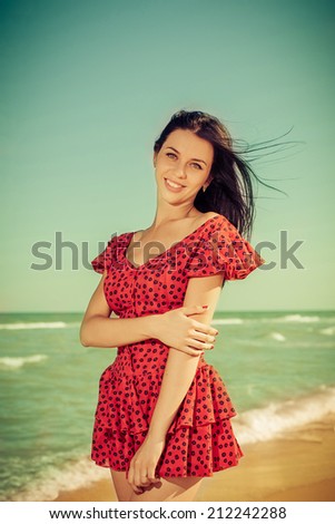 Young happiness girl in red dress on the Bathing Beach