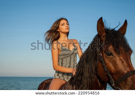Woman on horse. Young beautiful woman evening beach horse ride