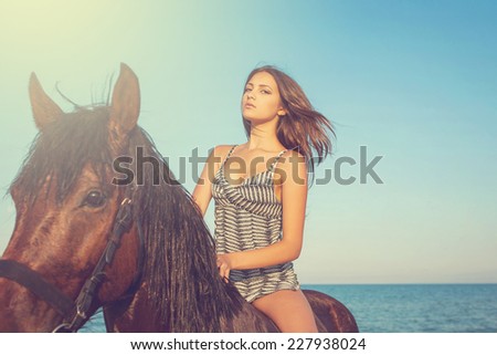 Woman on horse. Young beautiful woman evening beach horse ride
