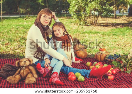 Happy family. Beautiful mother and daughter sitting at a picnic on a sunny day. With apples. Positive human emotions, feelings, emotions.