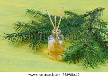 Fragrance sticks or bottle Scent diffuser with sprig fir on wooden background.