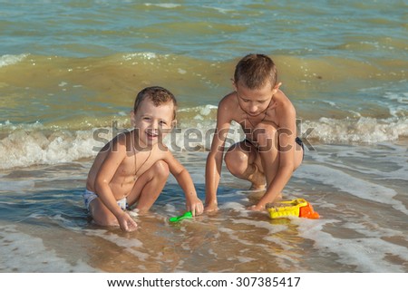 Happy family. Children - two boys having fun on the beach. Positive human emotions, feelings, emotions.