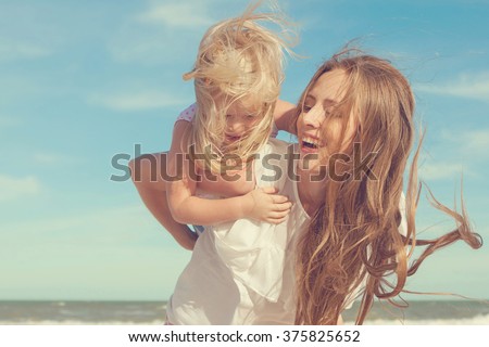 Happy family. Young beautiful  mother and her daughter  having fun on the beach. Positive human emotions, feelings. Retro toned