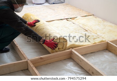 Work composed of mineral wool insulation in the floor, floor heating insulation , warm house, eco-friendly insulation, a builder at work