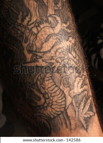 Tatuaje en el tobillo. Dragon oriental entre cañamo.