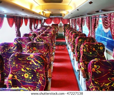 Empty luxury bus with red carpet and chairs