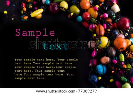Colorful beads necklace frame on black background with sample text