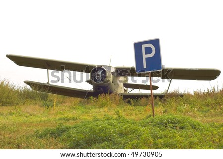 old broken-down plane in the parking lot with a parking sign, \