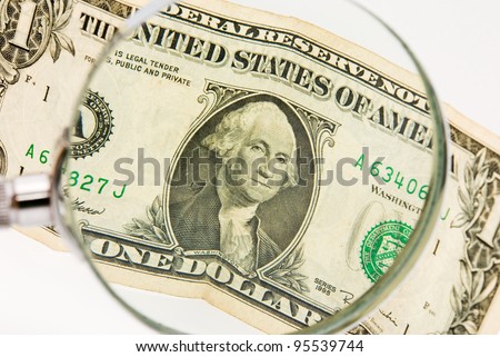 dollar photographed a magnifying glass, white background