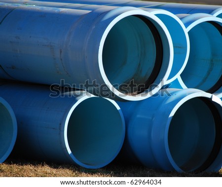 Stacked Blue Water Pipes / Tubes at a construction site.
