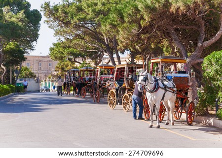 Row of horse with carriages in Mdina, old capital of Malta. Attraction for tourists.