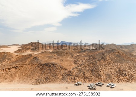 Beautiful Desert Landscape of Egypt. Safari cars go on the road between mountains.