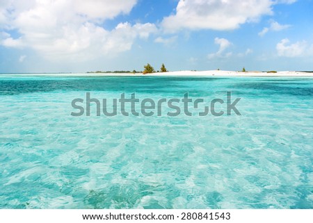 Soft wave of the sea on the sandy beach. Blue sky, white sand and place for text. Cuba, Caribbean sea.