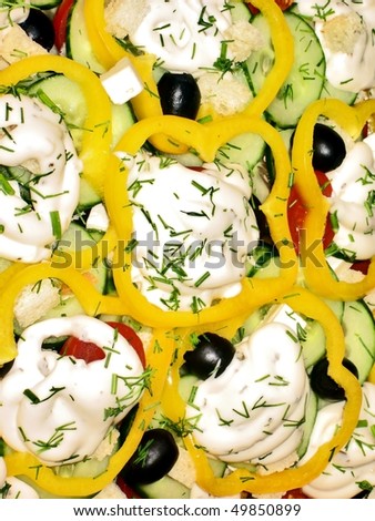 Salad decorated with olives and yellow paprika rings