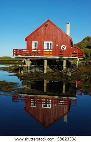 House on the sea coast and its reflection in still water