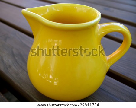 Small yellow jug for milk standing on the table