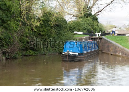 Narrow boat navigating a lock on a canal