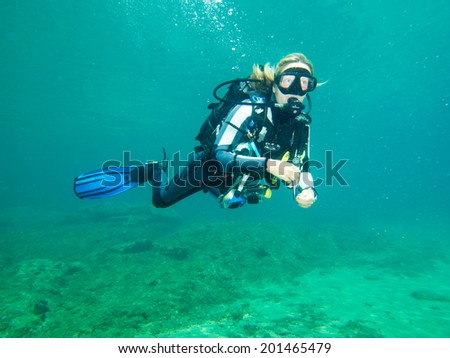 PALIOURI,GREECE-JUNE 27 2014: A female scuba diver taking part in a dive in the Agean Sea of the coast of Halkidiki Greece. Diving is an adventurous sport with diving locations all over the world.