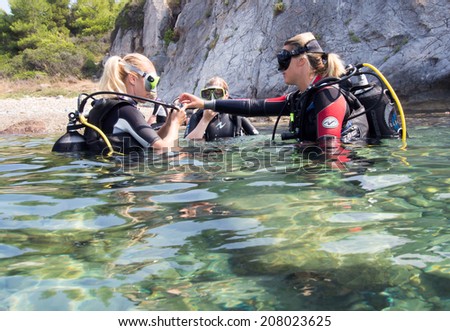 LOUTRA,GREECE - JULY 26 2014 : Female Scuba Divers take part in a training dive.More women are taking up the adventurous sport  of scuba diving .There are dive schools in most countries world wide
