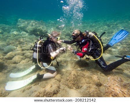 LOUTRA,GREECE - JULY 26 2014 : Female Scuba Divers take part in a traing dive.More women are taking up the adventurous sport  of scuba diving .There are dive schools in most countries around the world