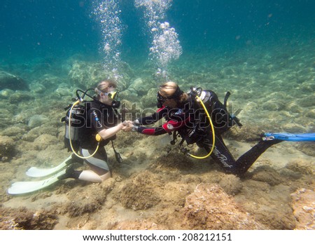 LOUTRA,GREECE - JULY 26 2014 : Female Scuba Divers take part in a traing dive.More women are taking up the adventurous sport  of scuba diving .There are dive schools in most countries around the world
